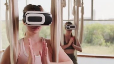 Avuç içlerini birbirine bastıran kızların yakın çekimleri namaz kılarken ve kulaklıkla meditasyon yaparken Aero yoga sınıfındaki hava hamağında otururken.