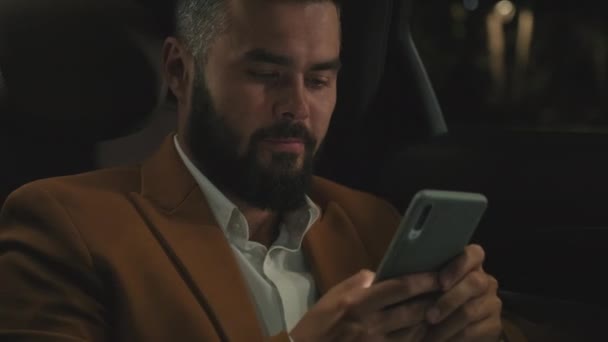 Close Homem Sério Negócios Usando Smartphone Enquanto Sentado Banco Trás — Vídeo de Stock