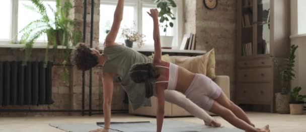 Spor Giyimli Formda Bir Kadın Küçük Bir Kızın Evdeki Yoga — Stok video
