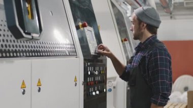 Polietilen film üreten büyük makine ekipmanları üzerinde parametreler belirleyen Kafkas bitkisi işçisinin orta yavaş yan görüntüsü