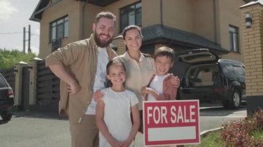  Banliyö evinden önce dört kişilik mutlu bir ailenin portresi satılık.