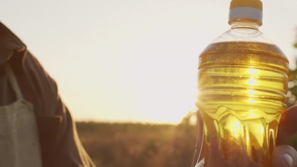 Nahaufnahme Einer Goldenen Flüssigkeit Sonnenblumenöl Plastikflasche Unkenntlichen Händen Eines Bauern — Stockvideo