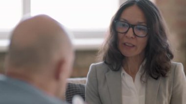 Gözlüklü orta yaşlı kadın psikoterapistin el bilgisayarı takibi duygusal erkek müşteriye danışmanlık