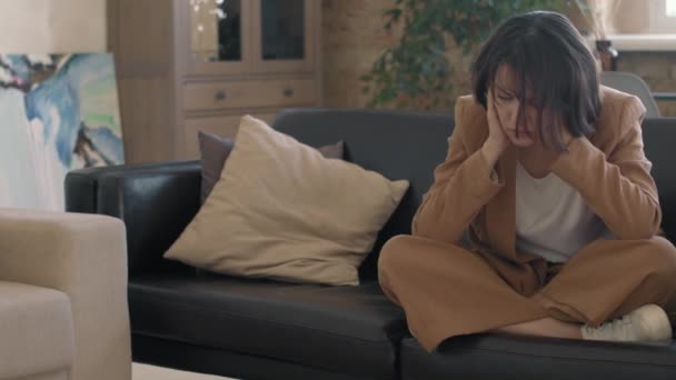 Pan Slowmo Καταθλιπτική Νεαρή Γυναίκα Κάθεται Σταυροπόδι Στον Καναπέ Σκυμμένο — Αρχείο Βίντεο