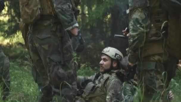 在秘密行动前 一队快乐的年轻高加索士兵在森林里放松下来 一边抽烟一边聊天 一边拍下手持镜头 — 图库视频影像