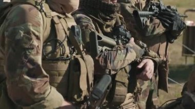 Bir grup istihbarat ajanının kamuflaj üniformalı ve keskin nişancı tüfekleriyle kırsal bölgelere baktığı el kamerası görüntüleri.