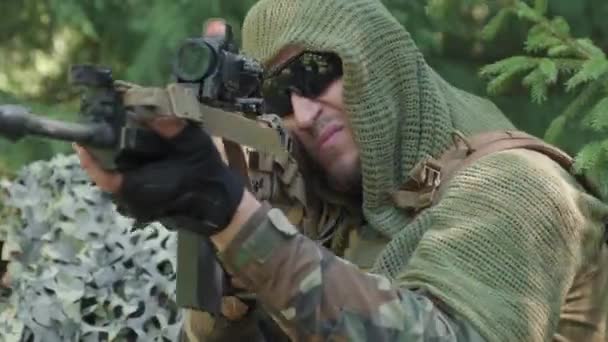 ジャングルで秘密作戦を行うカモフラージュ変装をした軍の狙撃手の閉鎖 狙撃ライフルで標的を狙う — ストック動画