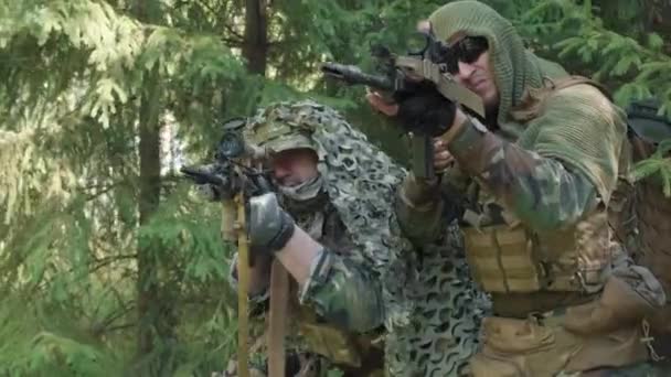 ジャングルで秘密の操作を行う狙撃ライフルを目指してカモフラージュの残忍な軍の男性の低角度中ショット — ストック動画