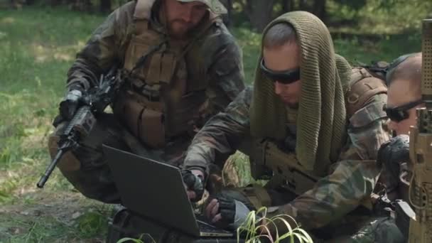 用手提电脑对伪装的军官中枪射击 在丛林里进行危险的军事行动 — 图库视频影像