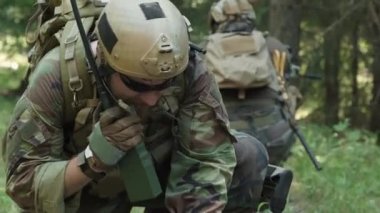 Ormandaki önemli askeri operasyonlar sırasında telsizle konuşurken bilgisayardan veri girişi yapan özel kuvvetler askerinin el kamerasıyla çekilmiş görüntüleri.