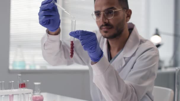 白い実験室のコートの中の男性科学者の閉鎖体内の肉のサンプルで検査 実験室のドロッパーでいくつかの液体を注入 反応を見て — ストック動画