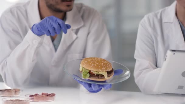 Långsam Närbild Oigenkännliga Forskare Som Undersöker Burgare Med Labbodlat Kött — Stockvideo