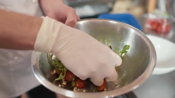 Powolne Zbliżenie Nierozpoznawalnego Szefa Kuchni Mieszającego Rukolę Pomidory Wiśniowe Orzeszki — Wideo stockowe