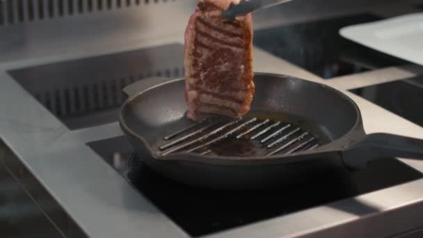 无法辨认的厨师慢动作特写 用火钳把多汁的牛肉排放在烤锅里 — 图库视频影像