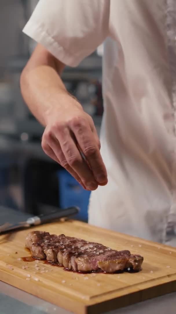 Lentidão Vertical Close Chef Irreconhecível Adicionando Sal Grosso Bife Ribeye — Vídeo de Stock