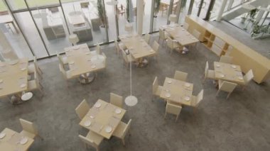 Üst manzara: Bej mobilyalı ve panoramik pencereli pahalı restoranların servis tablolarını kimse çekmiyor.