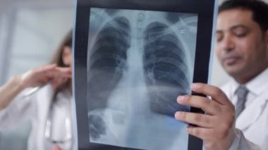 Modern doktorların ofislerinde oturup akciğerleriyle röntgen çekerken düşük açılı görüntüleri.