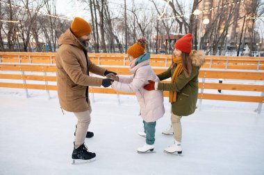 Ebeveynler çocuklarına kış tatilinde dışarıda buz pateni yapmayı öğretiyor.