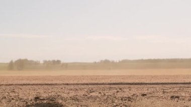Sıcak yaz gününde tozlu yolda ilerleyen modern gümüş arabanın alçak çekim görüntüleri.