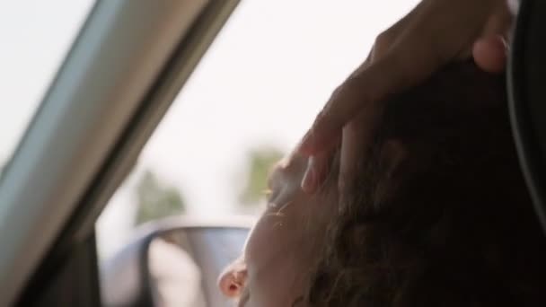 迷人的白种人女乘客把她的长发卷曲的头发固定在一起 享受着车窗打开带来的气流 — 图库视频影像
