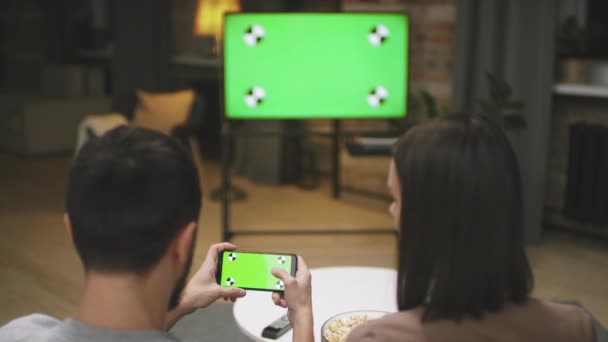 Vista Trasera Joven Pareja Encendiendo Partido Fútbol Transmitido Teléfono Inteligente — Vídeos de Stock