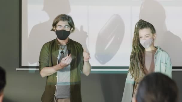 Yaratıcı Genç Girişimcilerin Yüz Maskeleri Takıp Projektör Ekranının Önünde Durdukları — Stok video