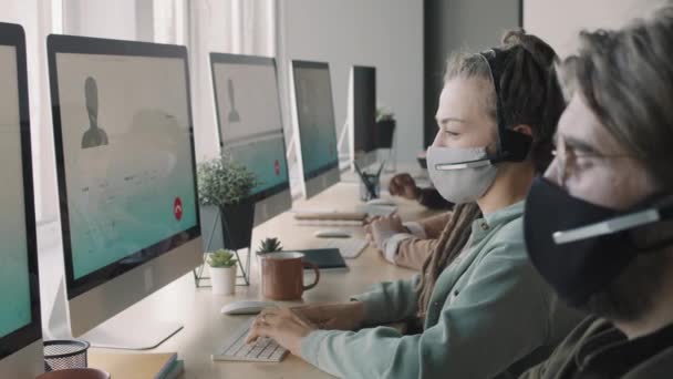 Vista Laterale Pan Dei Giovani Maschera Facciale Auricolari Seduti Davanti — Video Stock