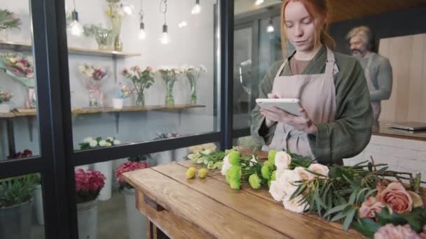 Medium Skott Unga Kvinnliga Blomsteraffär Arbetare Uppgifter Digitala Tablett Räkna — Stockvideo