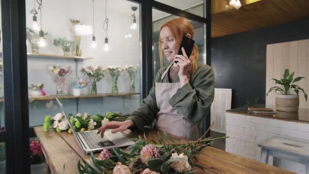 Średnie Ujęcie Ładnej Młodej Kwiaciarni Rozmawiającej Przez Telefon Podczas Pracy — Wideo stockowe