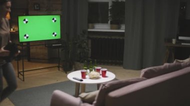 Dikiz aynasından, çeşitli futbol fanatik gruplarının kanepede oturup, akşamları birlikte futbol maçı izlediği orta ölçekli bir çekim.