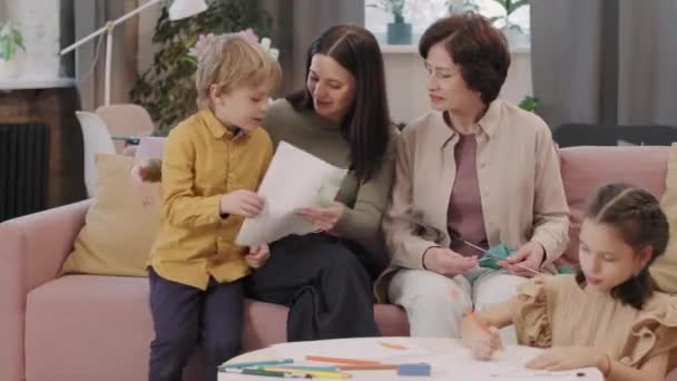 Mediana Toma Niño Bonito Corriendo Mamá Abuela Dándoles Dibujo Como — Vídeos de Stock