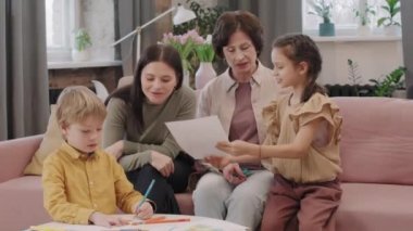 Annesi ve büyükannesinin oturma odasındaki kanepede otururken kardeşinin resim çizdiği orta boy bir resim.
