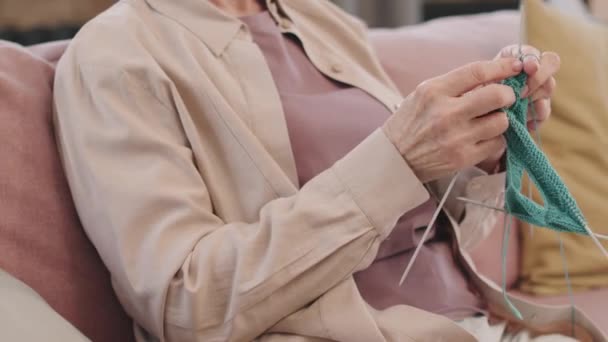 中段Pan与缓慢的难以辨认的老年妇女在沙发上放松与针织针织 — 图库视频影像