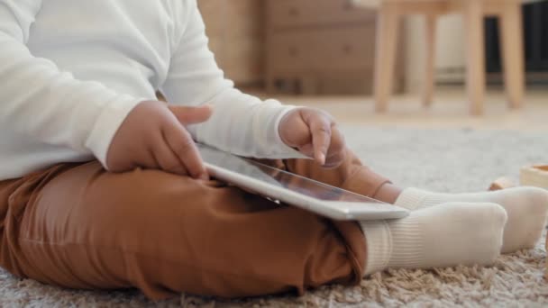 閉じるアップSlowmoの認識できない赤ちゃん男の子座っているラグと遊びます上のタブレット — ストック動画