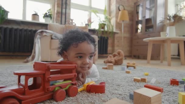 Sluiten Slow Van Schattige Peuter Jongen Liggend Tapijt Woonkamer Glimlachen — Stockvideo