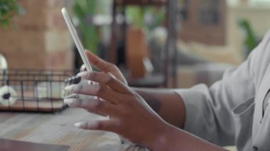 Tablet kullanan tanınmayan Afro-Amerikan kadının ellerini kapatın.