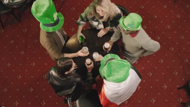 在庆祝圣帕克斯节的爱尔兰酒吧里 一群年轻的多民族朋友聚在餐桌旁 举杯庆祝圣帕克斯节 这是一张尽收眼底的照片 — 图库视频影像
