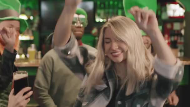 在当地爱尔兰酒吧举行的庆祝圣帕克斯节的活动中 有几位美丽的高加索女人在多民族朋友面前跳舞 动作缓慢 拍了些特写 — 图库视频影像