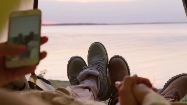 难以辨认的男女游客在恋爱中一起在帐篷里放松 用智能手机拍照 — 图库视频影像