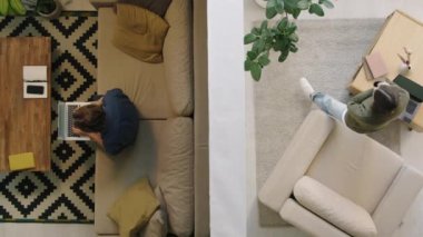Genç adamın evinde dizüstü bilgisayar başında otururken, kadın komşusunun telefonla konuşurken ve volta atarken en iyi görüntüsü.