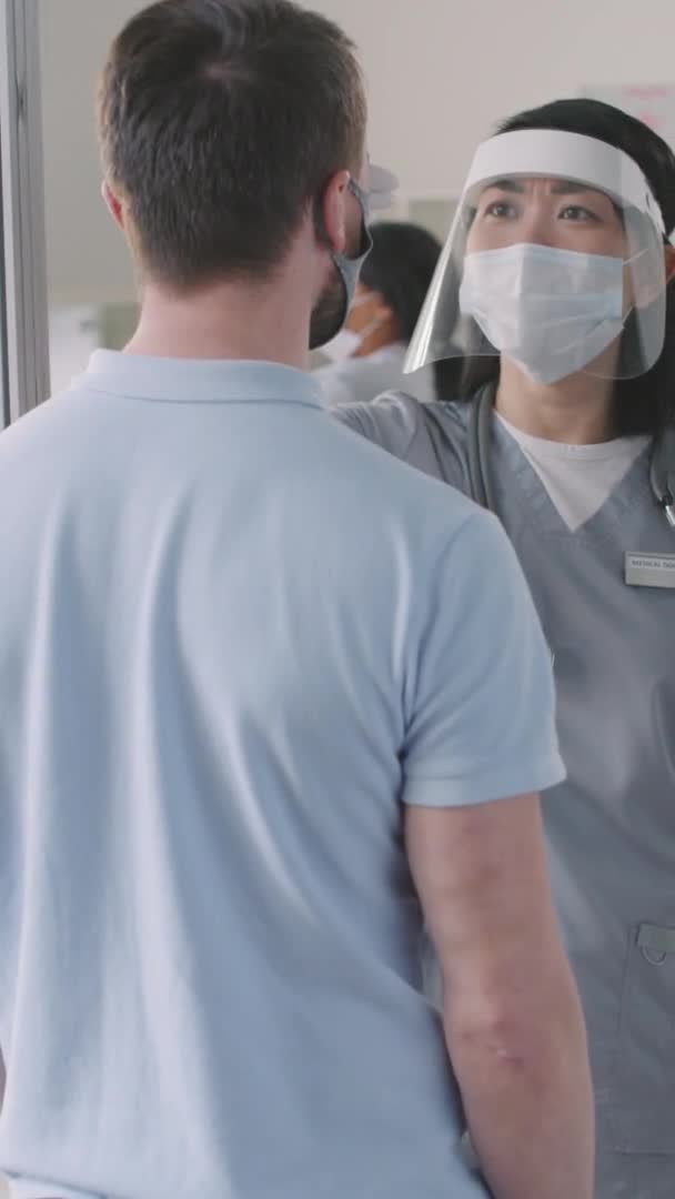 Vertical Rear View Medium Closeup Slowmo Nurse Wearing Protective Face — Stockvideo