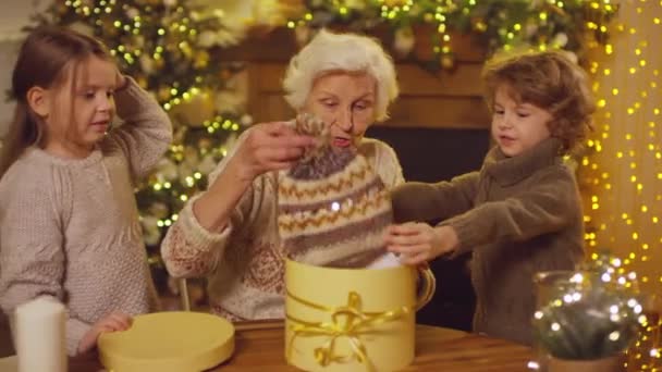 Elderly Lady Taking Cozy Knitted Hats Pompoms Out Christmas Box — Stock Video