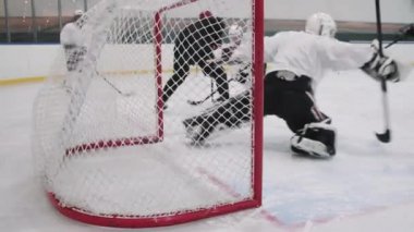 Tanımlanamayan hokey oyuncusunun yavaş çekimde top kalecilerin kapısına çarpıp gol attığı görüntüler.