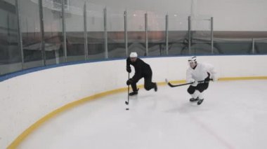 Yüksek açılı geniş açı, yavaş hokey oyuncusunun buz arenası boyunca top sürmesi ve karşı takımın üyesinin ona binip puck 'ın kontrolünü ele geçirmesi.