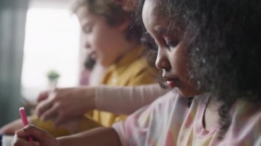 Sanat ve zanaat sınıfında resim çizen ve resim yapan çocukların yan görüş açısını kapat