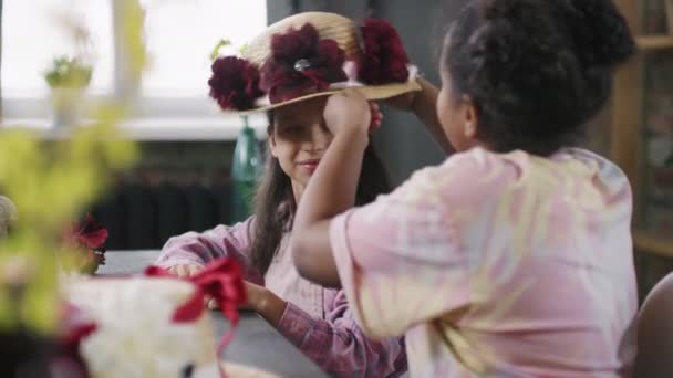 Közepes Adag Vidám Fekete Lány Mosolyog Szalmakalapot Tesz Virágokkal Díszítve — Stock videók