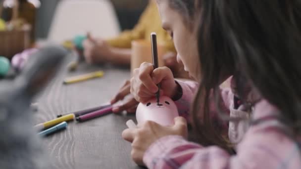 复活节作坊或美术课期间 坐在桌旁 用粉红笔杯画兔子脸的可爱姑娘的近照 — 图库视频影像