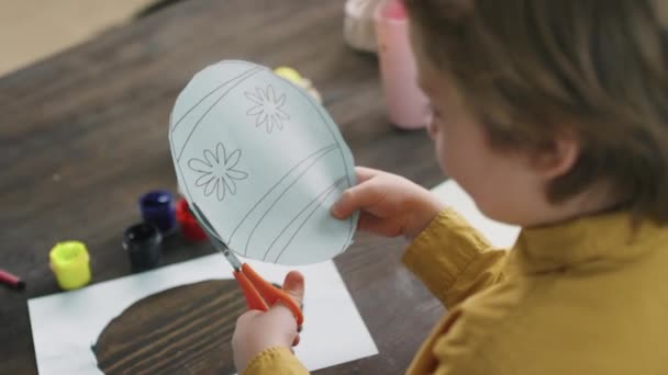 Handheld Shoulder Shot Little Boy Sitting Table Cutting Easter Egg — Stock Video