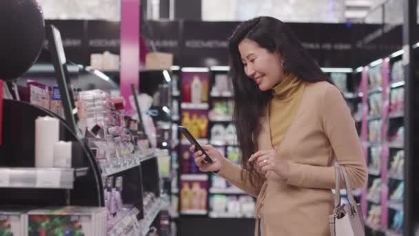 Kozmetik Mağazasında Makyaj Ürünleriyle Çekim Yapan Akıllı Telefonlara Gülümseyen Çekici — Stok video