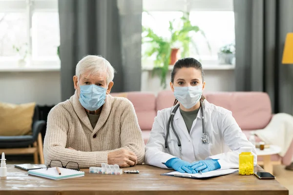 Kranke Ältere Patientin Und Junge Brünette Ärztin Schutzmasken Sitzen Nebeneinander — Stockfoto